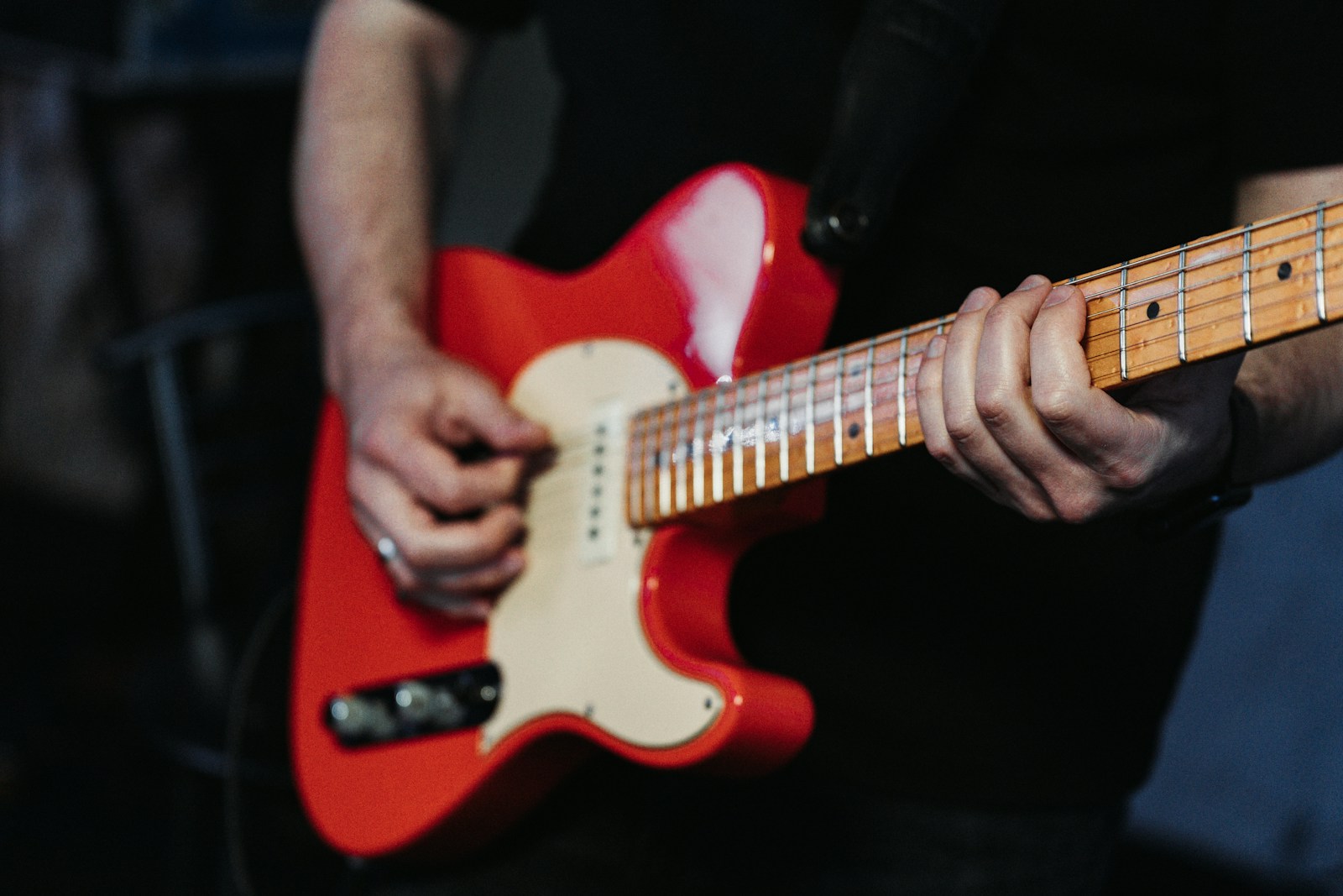 a close up of a person playing a red guitar